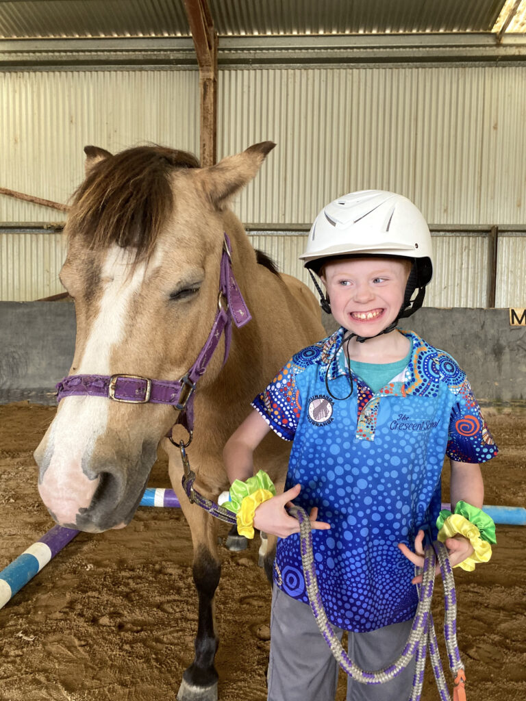 young boy smiling with horse